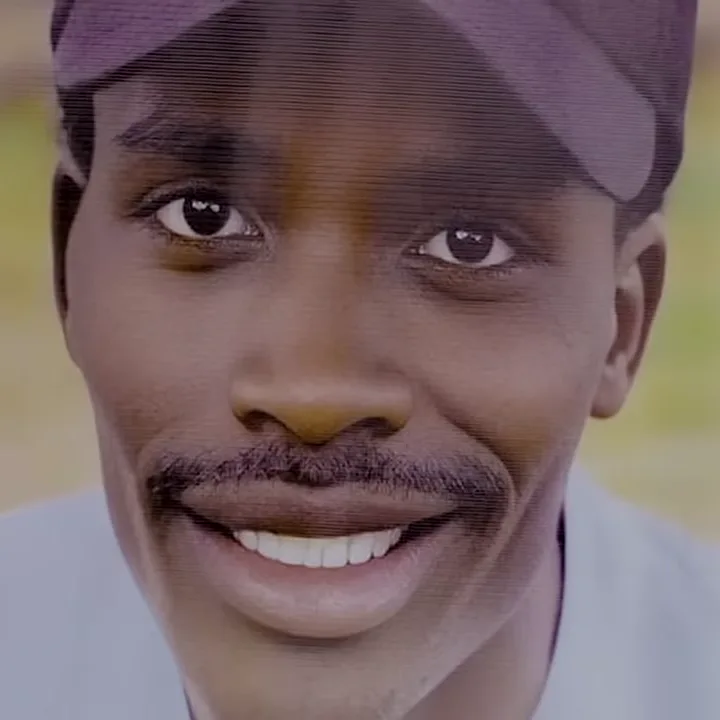 Portrait of Eric Shieni, smiling, wearing a cap.